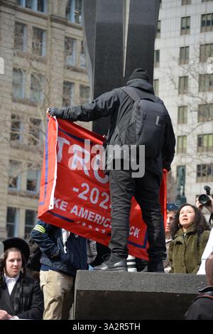 Counter protester with a MAGA flag at a rally for student activist Mahmoud Khalil in Foley Square in Lower Manhattan. Stock Photo