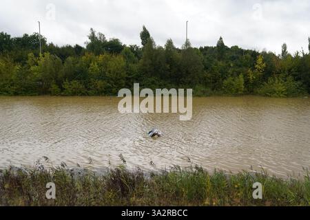 The open boot of a car is visible above the water where the vehicle is submerged in flood water on the A421 in Marston Moretaine, Bedfordshire. Parts of Britain have been struck by flash floods after some areas saw more than a month's worth of rain in 24 hours. Heavy rainfall has seen parts of Northamptonshire, Bedfordshire and London submerged causing widespread travel disruption and damage to properties. Picture date: Monday September 23, 2024. Stock Photo