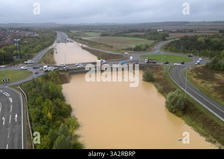 The open boot of a car is visible above the water where the vehicle is submerged in flood water on a421 in Marston Moretaine, Bedfordshire. Parts of Britain have been struck by flash floods after some areas saw more than a month's worth of rain in 24 hours. Heavy rainfall has seen parts of Northamptonshire, Bedfordshire and London submerged causing widespread travel disruption and damage to properties. Picture date: Monday September 23, 2024. Stock Photo