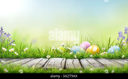 Five painted easter eggs celebrating a Happy Easter on a spring day with a green grass meadow, bright sunlight and a warm colour background with copy Stock Photo