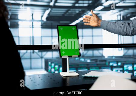Engineers using isolated screen tablet in data center, managing server virtualization. Workers using mockup device in server room, sustaining long term infrastructure reliability Stock Photo