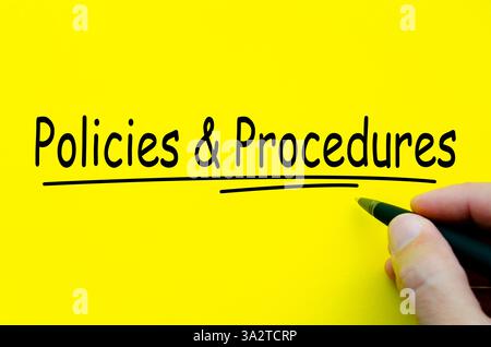Policies and Procedures hand written text on yellow notepad. Stock Photo