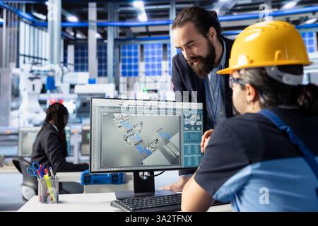 Solar panels plant manager doing quality control in office, ensuring high efficiency. Photovoltaics factory supervisor checking work done by employee calibrating robotic arms Stock Photo