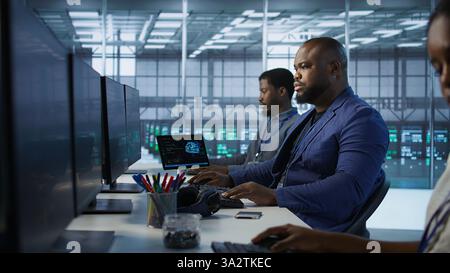 Portrait of happy server room worker developing disaster recovery plans ensuring minimal downtime. Smiling technician in data center using data analytics to monitor performance, camera A Stock Photo
