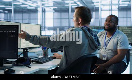 Manager admonishing programmer after making error damaging high tech data center. Supervisor scolding IT staff member after doing mistake in server room affecting supercomputers, camera A Stock Photo