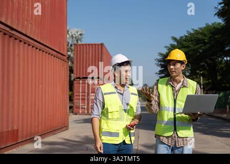 Strategic Planning. Engineers discussing logistics using a laptop at a site. Stock Photo
