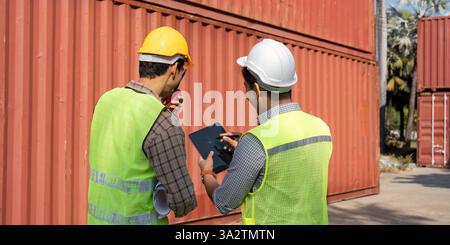 Logistics planning. Engineers reviewing project details at a container yard. Stock Photo