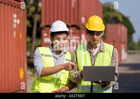 Digital Collaboration. Engineers using technology for logistics planning outdoors. Stock Photo