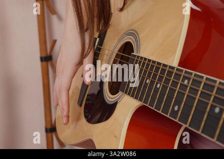 Closeup woman guitarist is practicing skills of playing on Spanish six string acoustic guitar. Selective focus Stock Photo