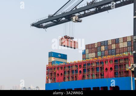 Crane lifting shipping containers onto container ship Stock Photo - Alamy
