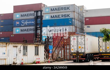 Hong Kong. China- 02.18.2025. Stacks of shipping container and container delivery trucks in the Port of Hong Kong. Stock Photo