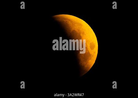 A lunar eclipse is visible above Surrey Quays in London as the full moon passes into Earth's shadow. Unlike in other parts of the world, except for some extreme western areas of the UK, the eclipse will be almost entirely partial. A lunar eclipse occurs when the Earth, sun, and moon are almost exactly in line and the moon is on the opposite side of the Earth from the sun. Picture date: Friday March 14, 2025. Stock Photo