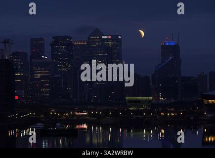 A lunar eclipse is visible above Canary Wharf in London as the full ...