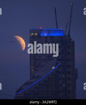 A lunar eclipse is visible above Canary Wharf in London as the full ...