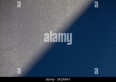 Intricate lines on a black plastic facade, with a diagonal shadow creating depth and texture Stock Photo