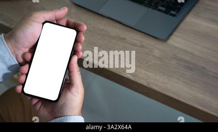 Top view Mockup image hand using a smartphone man Holding Cell Phone With Blank Screen Stock Photo