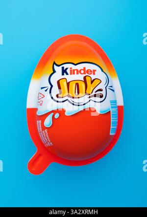 LONDON, UK - JANUARY 30, 2025: Kinder original milk chocolate egg with surprise toy inside on blue. Stock Photo