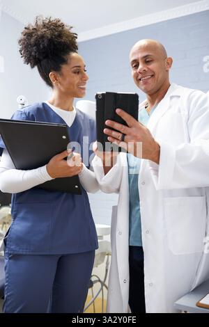 Medical Professionals Collaborating Using Technology in a Modern Clinic Setting Stock Photo