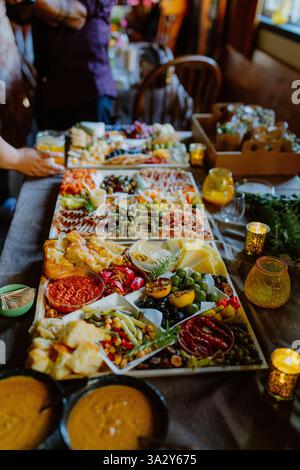 A vibrant charcuterie board with cheeses, olives, and dips Stock Photo
