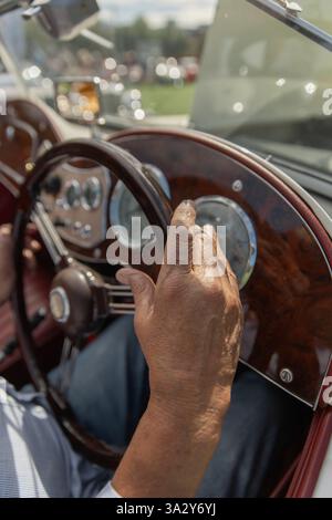 Man's hand on wooden steering wheel on vintage Convertible Stock Photo