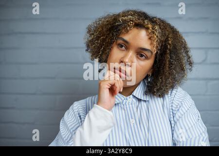 Pensive Young Woman in an Introspective Pose Pondering Thoughts Stock Photo