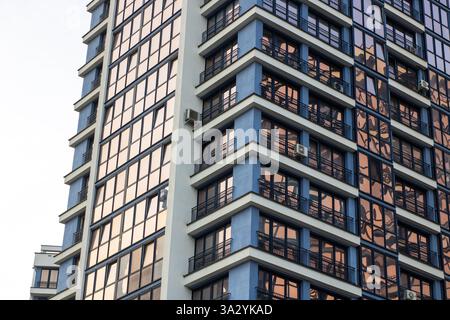A very tall building featuring numerous windows and balconies, creating an impressive architectural design within the urban landscape Stock Photo