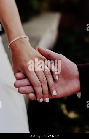 Man and woman holding hands showing off engagement ring Stock Photo