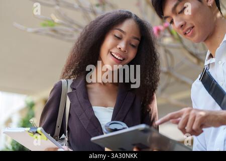 Collaboration and Digital Communication. Engaging conversation about sustainability between two young professionals. Stock Photo