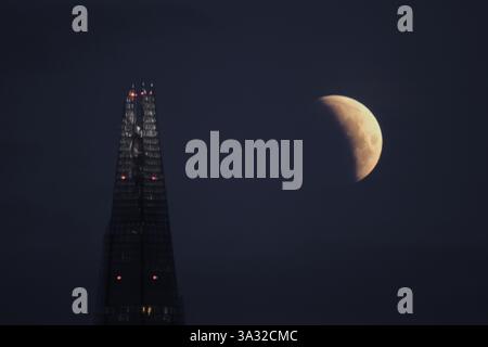 Partial blood moon lunar eclipse over The Shard, London, 14th March 2025 Stock Photo