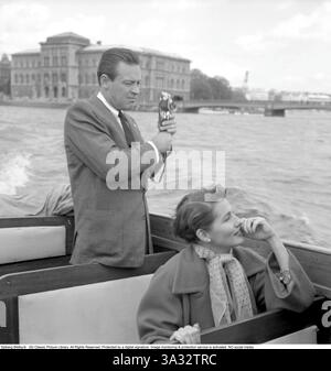 William Holden 1954. American actor and one of the biggest box-office draws of the 1950s. 17 april 1918-12 november 12 1981. Pictured with his wife Brenda Marshall while visiting Stockholm Sweden 1954. Brenda Marshall was an american film actress, 1915-1992.   Note the details about the camera William Holden is using, a Kodak Stereo Camera. A 35 mm stereo camera produced between 1954 och 1959. The camera took twin shots of the scene, and the slides could then be viewed in dedicated image viewers to experience the depth and effect of the twin lense photography. Conard ref 2732  *** Local Captio Stock Photo