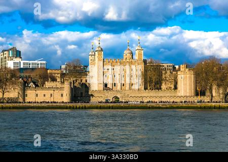Picturesque close-up view of the famous Tower of London with its iconic White Tower, seen from across the River Thames on a sunny day with a blue sky. Stock Photo