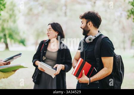 Multicultural students collaborating on school tasks in a green park Stock Photo
