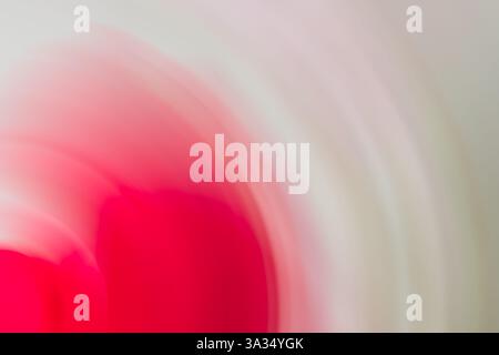 A captivating abstract image featuring swirling shades of vibrant pink blending with soft white. The blurred effect creates a dynamic and dreamy visua Stock Photo