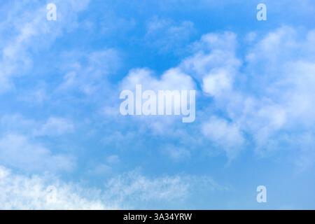 A beautiful heart-shaped cloud floats in a bright blue sky, creating a dreamy and romantic scene. The soft, fluffy texture of the clouds enhances the Stock Photo