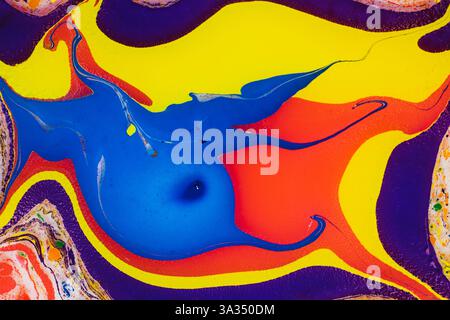 A vivid and colorful abstract composition featuring swirling patterns of blue, yellow, red, and orange paint, with accents of purple and white. Stock Photo