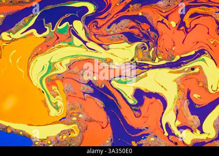 Vibrant abstract image featuring a swirling mix of orange, blue, yellow, and red. This dynamic composition captures the fluidity and intensity of colo Stock Photo
