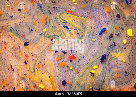 This image captures an intricate pattern of vivid, swirling colors and dynamic splatters on a textured surface, creating an engaging abstract artwork. Stock Photo