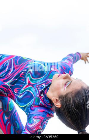 A woman in a colorful outfit passionately dances, embodying the spirit of LGBTQIA+ pride and creative expression. Her vibrant attire reflects fluidity Stock Photo