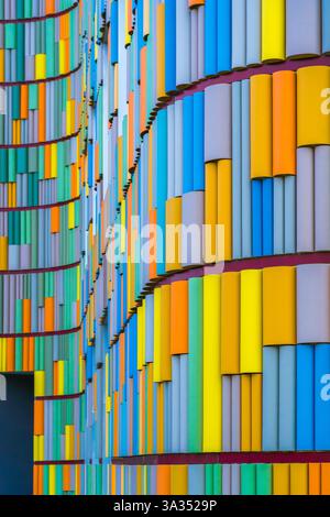 A striking image depicting the vivid, multicolored facade of a contemporary building, showcasing a dynamic array of vertical panels in various hues. Stock Photo