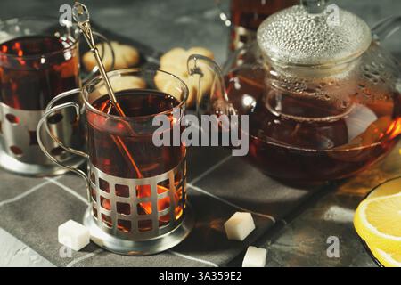 Glasses of tea in metal holders served on grey table, closeup Stock Photo