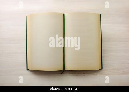 Vintage book with green registration tape open with blank pages on wooden table. Top view. Stock Photo