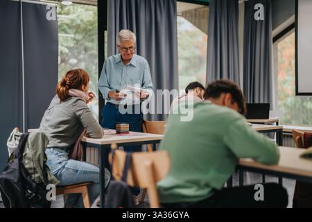 Elderly professor engaging with attentive students in classroom setting Stock Photo