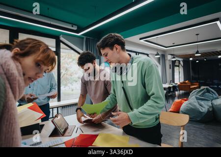 College students collaborating on a project in modern classroom with guidance Stock Photo