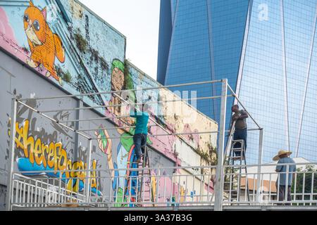 a group of workers installing or maintaining in front of  mural by Mr Perol on the side on a side of a building, Kuala Lumpur, Malaysia, Asia Stock Photo