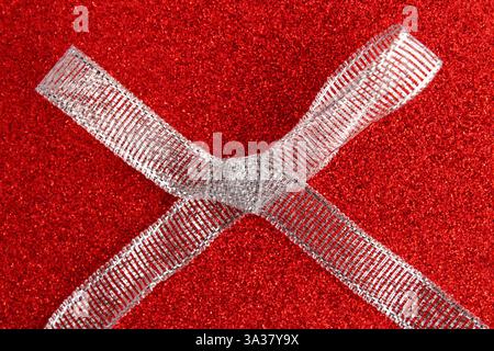Large silver glitter bow on a red background Stock Photo