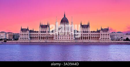 Hungarian parliament building reflecting on danube river at sunset with colorful sky, budapest, hungary, europe Stock Photo