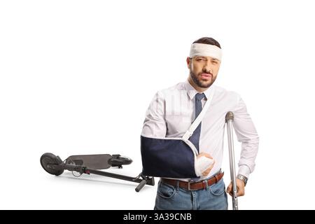 Man injured in electric scooter accident standing with a crutch isolated on white background Stock Photo