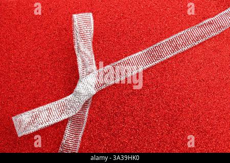 Silver glitter bow on a red background Stock Photo