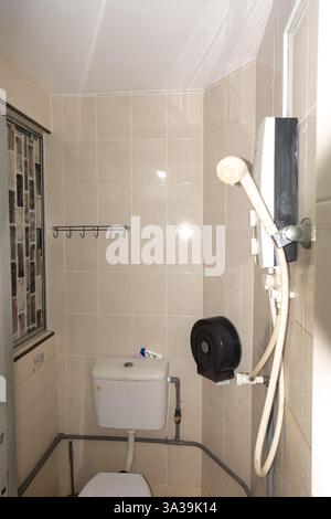 Bathroom with wc toilet and shower in a narrow bathroom, Shower cabin, cheap hotel, Malacca, Malaysia Stock Photo