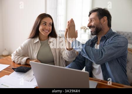 Cheerful excited husband and wife giving high five Stock Photo